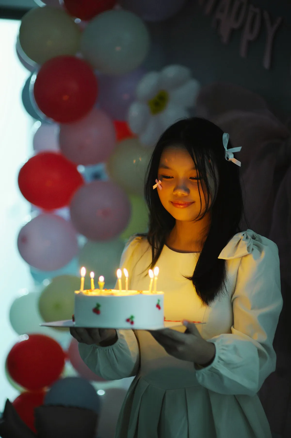 Jeune fille tenant son gâteau d’anniversaire aux bougies