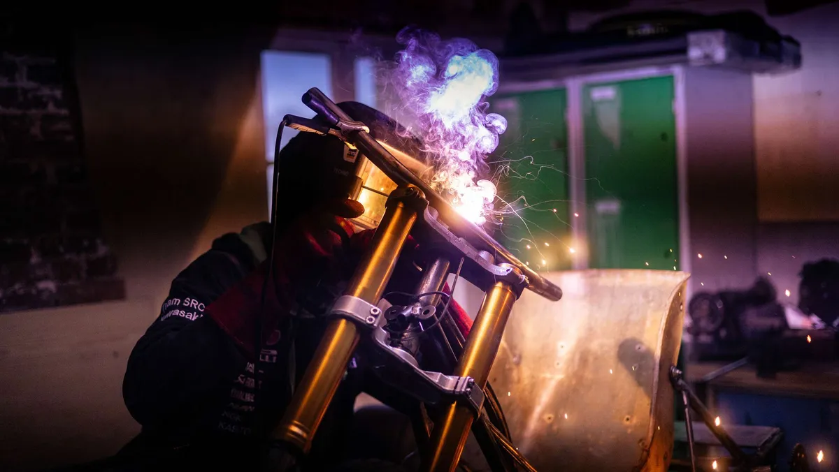 Atelier moto, ambiance sombre et étincelles